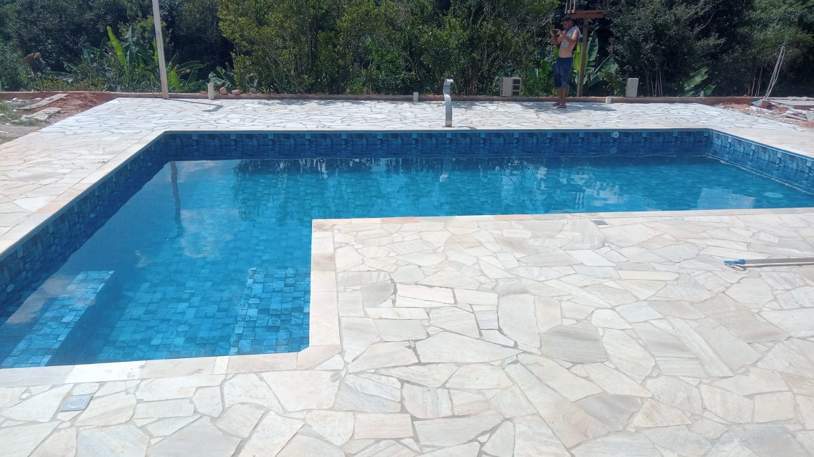 Piscina em L com pedra calcária